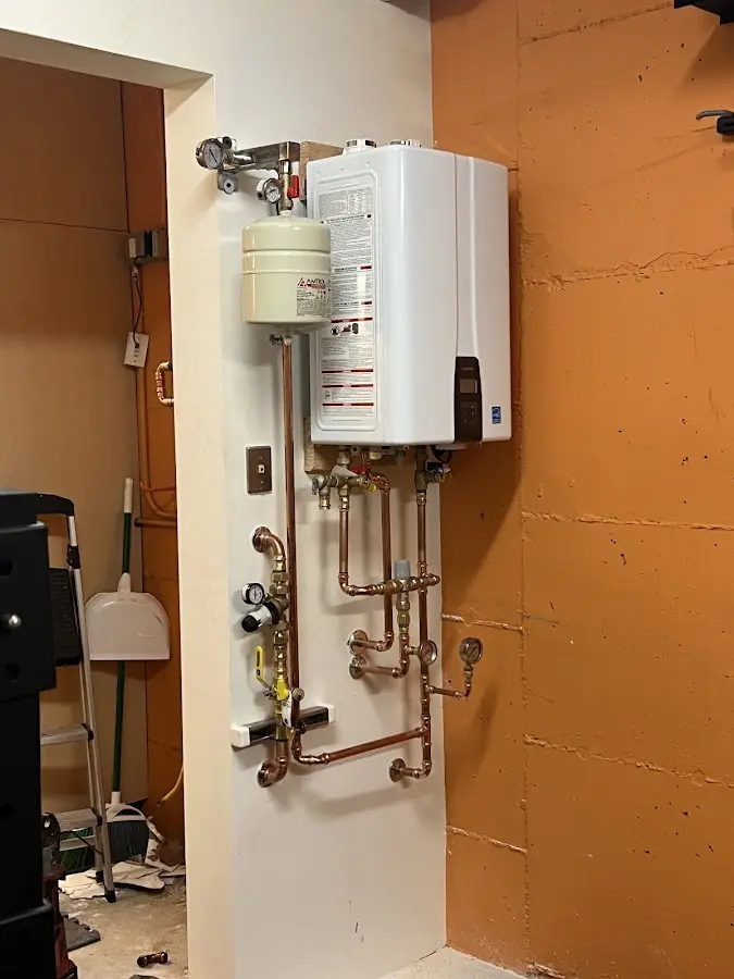Plumbing technician inspecting water heater connections in Canandaigua